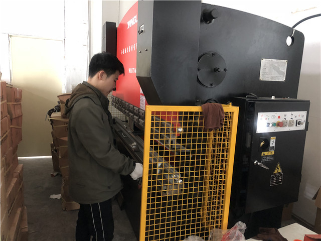 Workers work on Press Bracket Machine for TV bracket